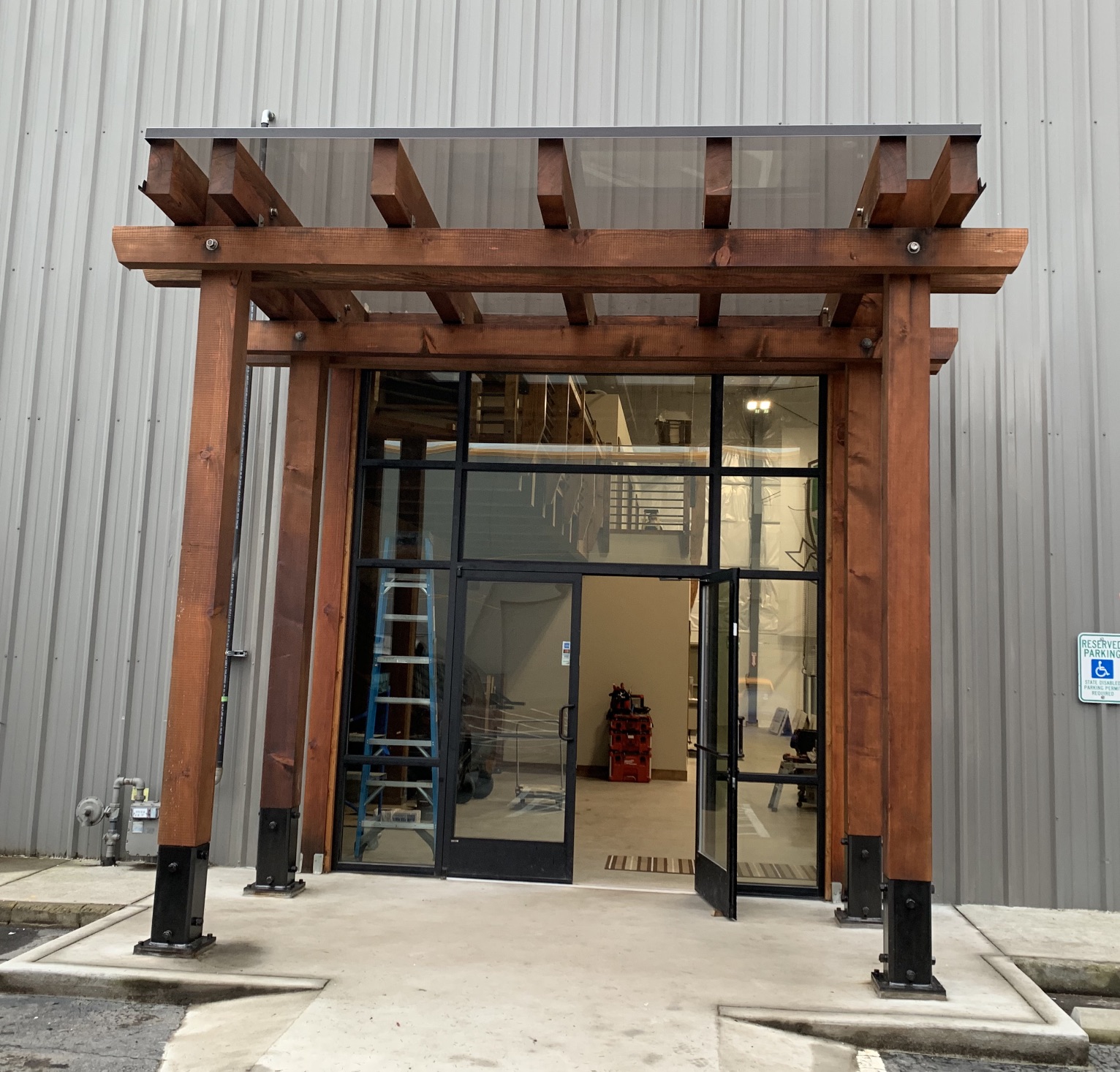 Commercial timber pergola entry with glass canopy roof